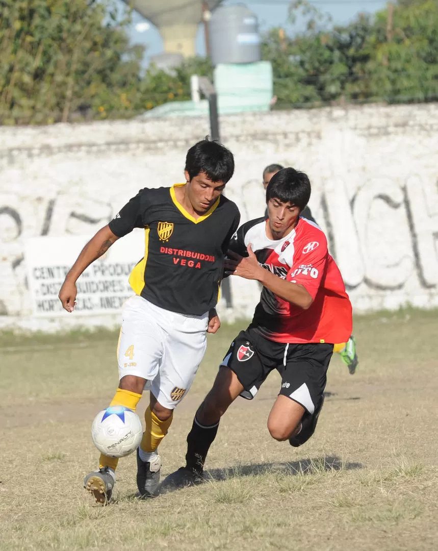 EL CAMPEÓN VIENE EN ALZA. Franco Alvarez, de Lastenia, se lleva la pelota ante la marca de Luis Mamaní, de Amalia. 