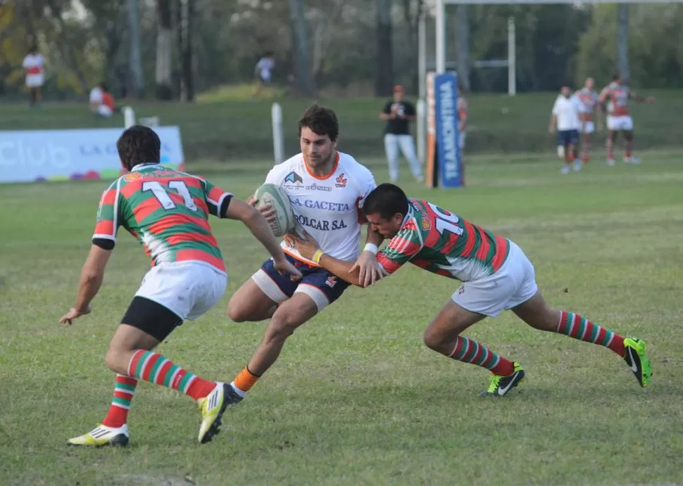 NO SERÁ FÁCIL DE BAJAR. Máximo Ledesma intenta escapar a toda velocidad de la marca de dos jugadores de Huirapuca. 