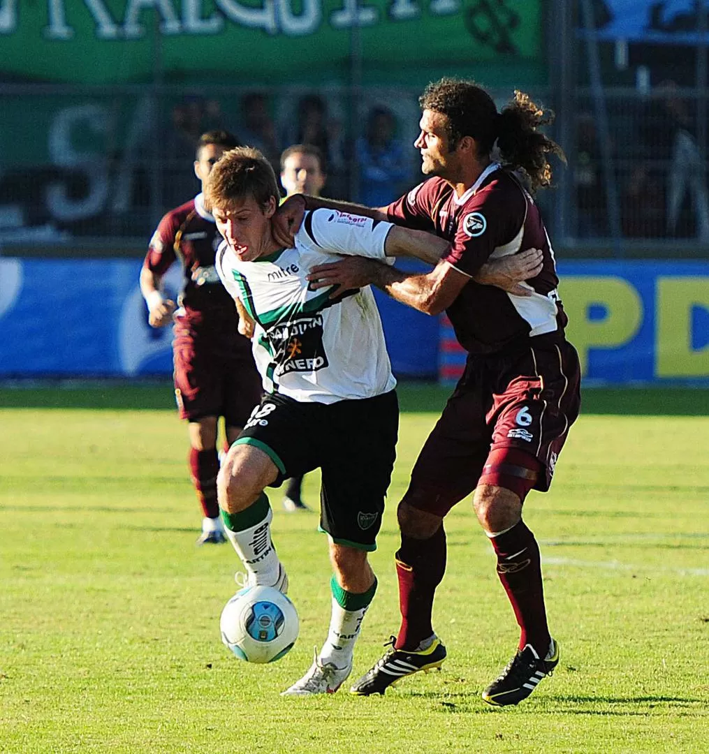 POCO ELEGANTE. Vizcarrondo intenta quitarle la pelota a Claudio Riaño. 