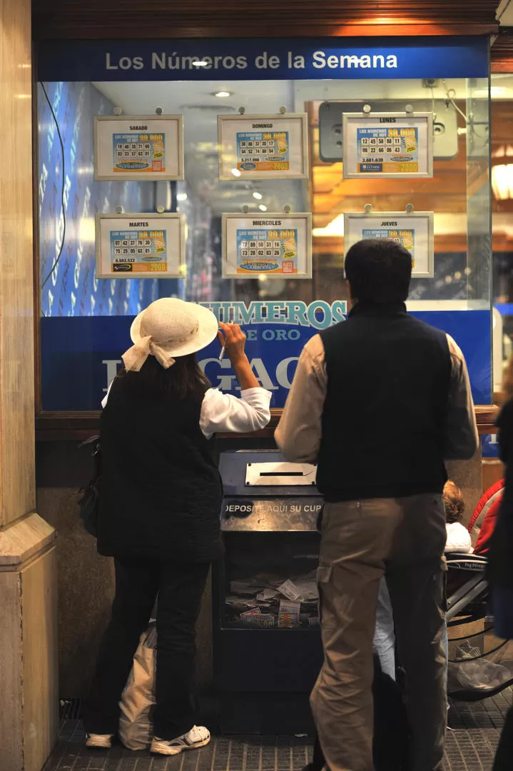 MÁXIMA EXPECTATIVA. Dos lectores controlaban ayer los números en la puerta de LA GACETA. LA GACETA / FOTO DE OSCAR FERRONATO