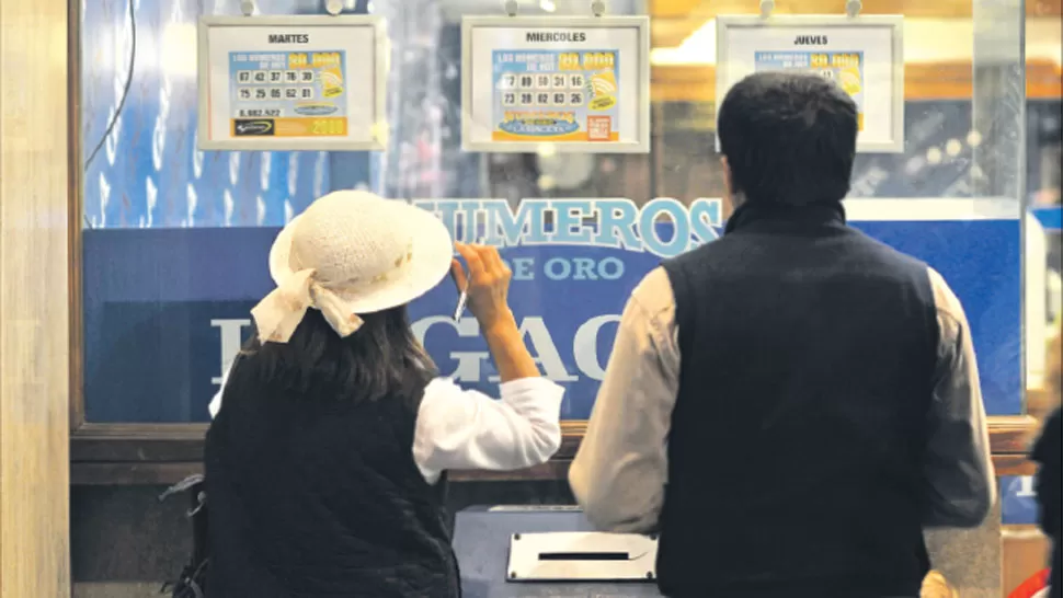 MÁXIMA EXPECTATIVA. Dos lectores controlaban ayer los números en la puerta de LA GACETA. LA GACETA / FOTO DE OSCAR FERRONATO