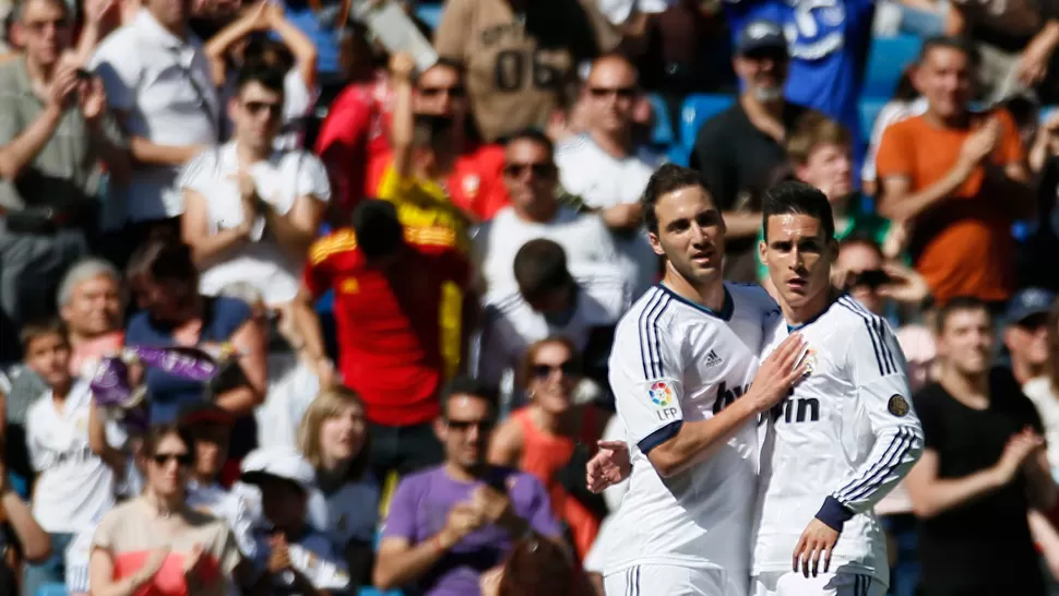 ADIOS. El Pipita recibe los saludos de José Callejón, después de marcar su último gol con la camiseta Merengue. REUTERS