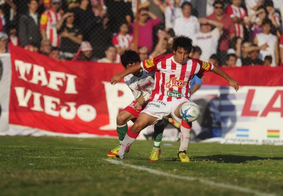 NO SE LA QUITA NADIE. Luis Vega, pegado a la línea, cuida la pelota ante la dura marca Exequiel Narese. 