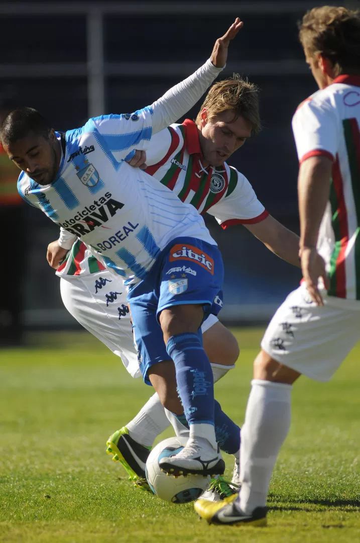 CRUCE. Méndez intenta sacarse de encima la marca de dos futbolistas de la lepra, que festejó el triunfo como un título. 