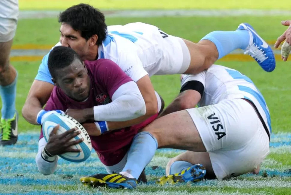 CON LA POTENCIA NO ALCANZÓ. El Tucumano Gabriel Azcárate intenta en vano frenar a un jugador de Inglaterra con la ayuda de un compañero. Los euorpeos fueron muy superiores al seleccionado argentino que hizo agua en todos lados.  