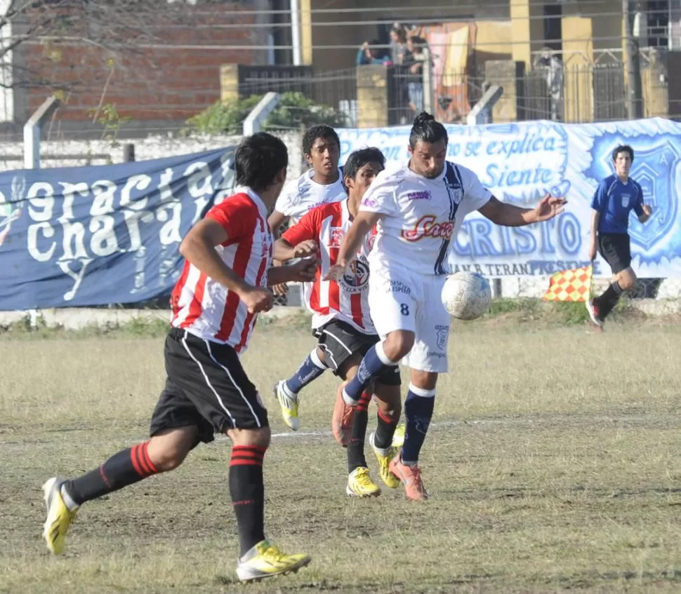 GRAVITANTE. Gerez, de San Juan, se lleva la pelota ante la marca de Escobar. 