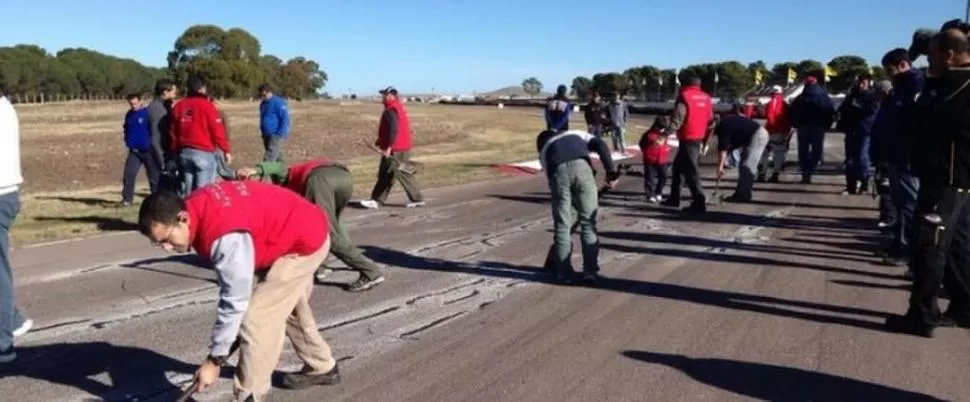 ENJABONADO Y PEGAJOSO. Auxiliares de pista tratan de neutralizar los efectos de la brea que pusieron a las rajas que tenía el trazado. 