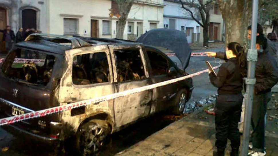 DESTRUIDO. El Peugeot 807 de Corral se encontraba estacionado frente a su domicilio particular. FOTO TOMADA DE INFOBAE.COM