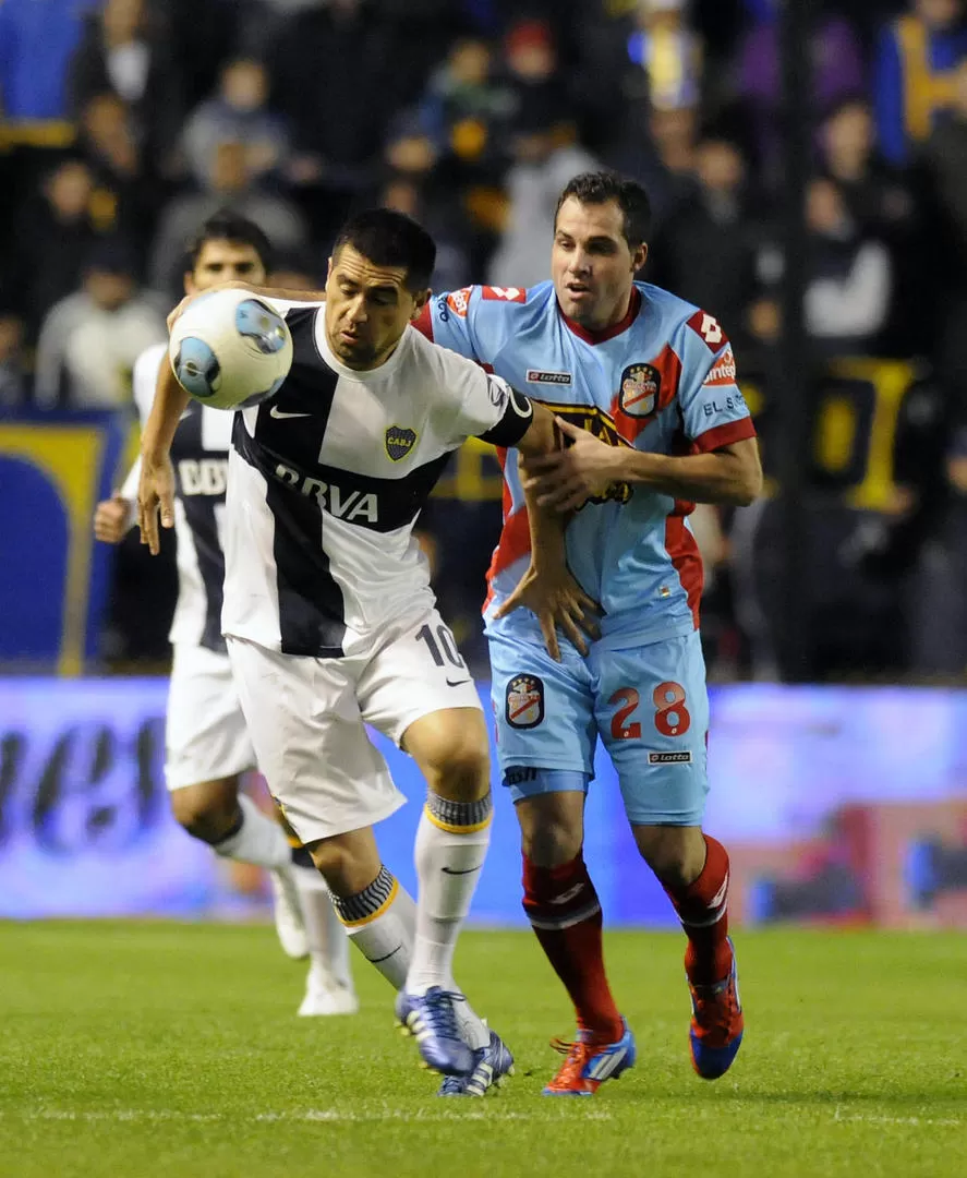 AVANCE DE 1O. Riquelme se lleva la bocha y González no sabe cómo frenarlo. 