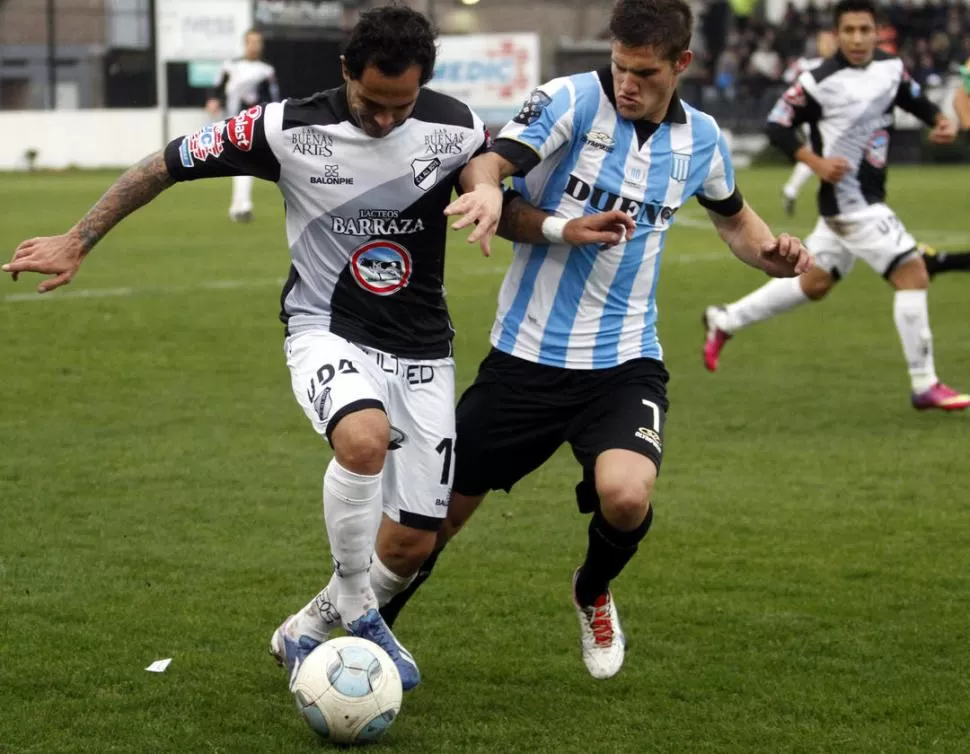 CUERPO A CUERPO. Zuculini sostiene la marca ante el tucumano Perea. 