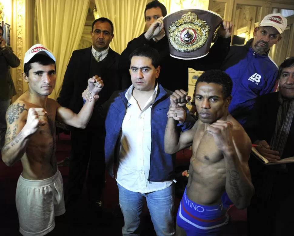 EN EL SALÓN BLANCO. Bad Boy Ruiz, René Bustos, uno de los organizadores del festival, y La Pantera Pichardo luego del pesaje. Detrás, el cinturón Latino OMB de los moscas que estará en juego en el combate, que fue presentado en Casa de Gobierno. 