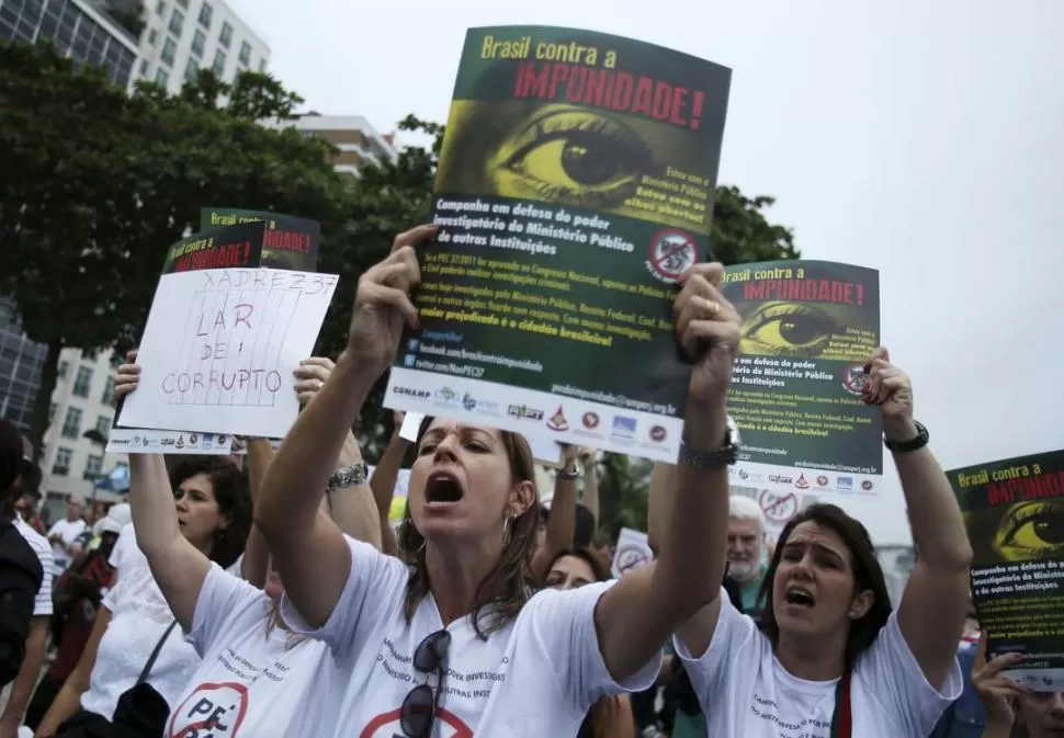 EN COPACABANA. Un grupo de manifestantes reclama con pancartas contra el poder que tiene la Policía en el manejo de las investigaciones penales. REUTERS