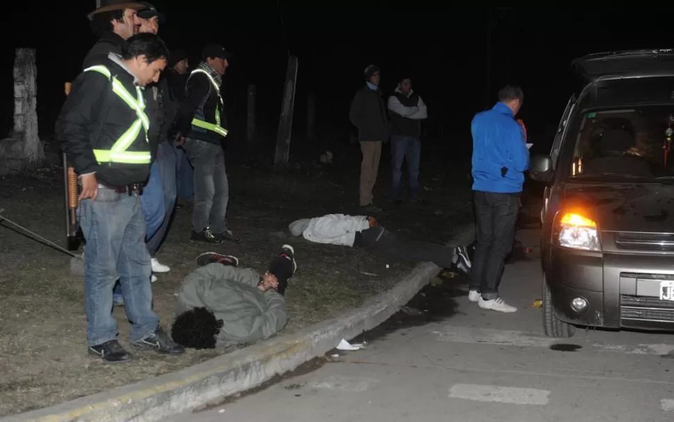 EN EL CÉSPED. En un control vehicular, la Policía redujo a los sospechosos. LA GACETA / FOTO DE ANTONIO FERRONI