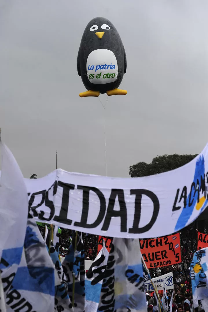 AVE MARINA GIGANTESCA. El amayismo hizo volar un globo con la forma del pingüino. Abajo, el camporismo de la UNT hizo flamear una bandera. LA GACETA / FOTO DE JORGE OLMOS SGROSSO