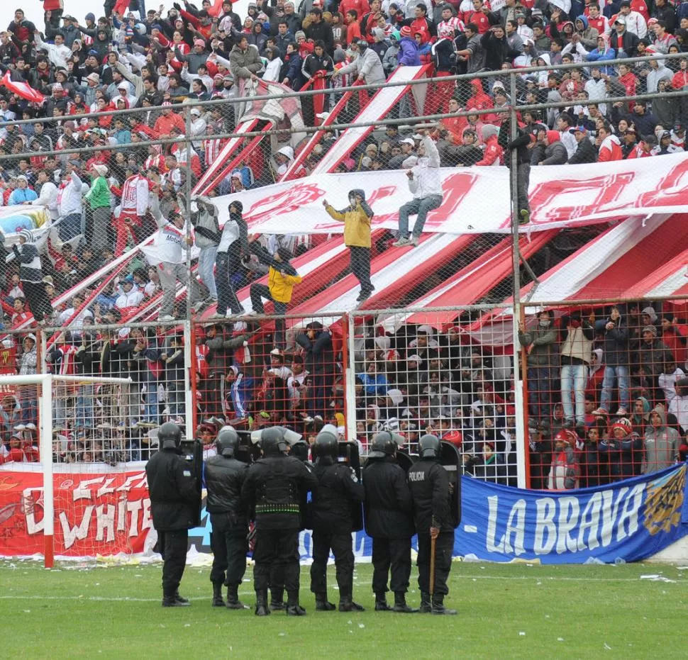 ALGARABÍA. Cuando el partido se moría con el triunfo santo, los hinchas de la tribuna Rondeau se treparon a la cerca olímpica y obligaron a la Policía a reposicionarse. LA GACETA / FOTO DE HECTOR PERALTA 