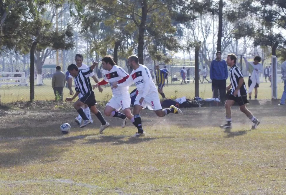 MARCA. Hugo Chávez, de Abogados A+ se lleva la pelota ante tres adversarios. 