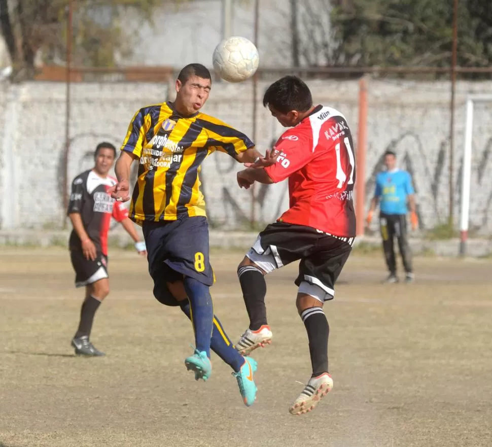 CATEGORICO. Julian Correa, de Experimental, y Luis Córdoba, de Amalia, luchan en lo alto por la posesión de la pelota. 