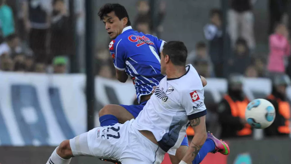 TRIUNFO CERVECERO. Quilmes le ganó a los mendocinos 1-0. La curiosa escena muestra a los protagonistas que se olvidaron la pelota en plena lucha. TELAM