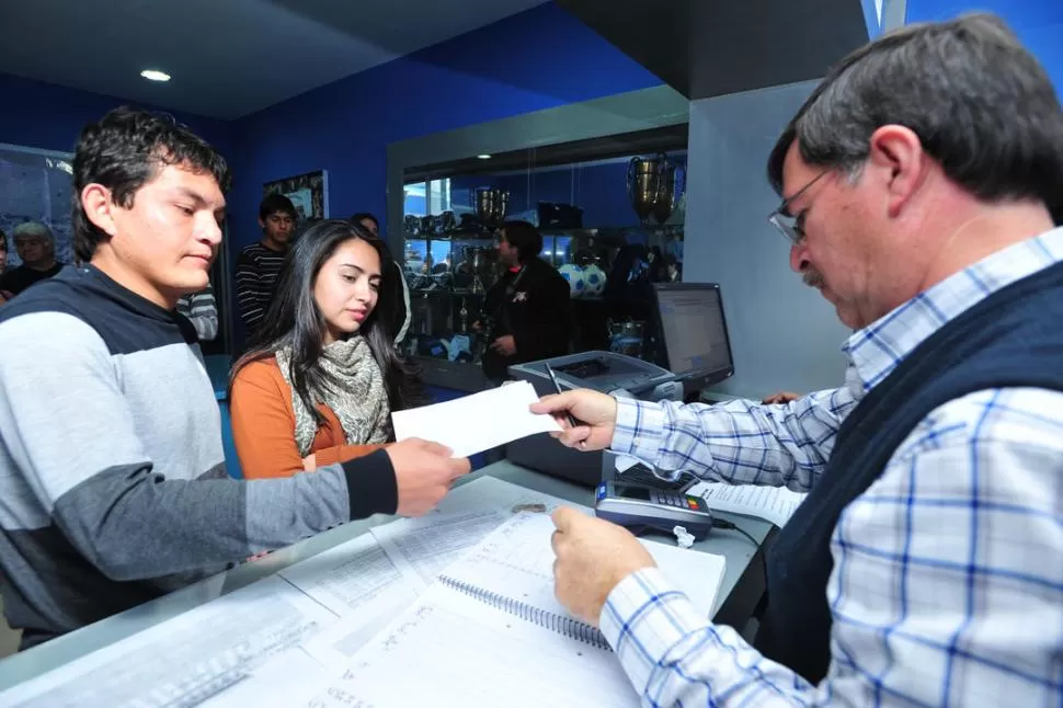 PRIMERA PARTE. Juan Vizcarra, empleado del club, entrega el recibo al Pulguita y a su esposa. Luego, posó para la foto. 