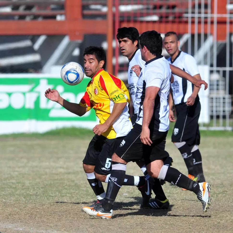 NO ALCANZÓ. Pablo Lucena inteta llevarse la pelota ante la doble marca de los jugadores de los julianos. 