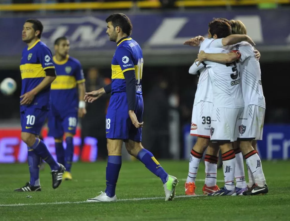 LAS POSTALES DEL RESULTADO. Los jugadores de Newell's se funden en un abrazo ganador; los de Boca empiezan a dejar la cancha llevándose el gusto amargo de la derrota en un cotejo electrizante. 