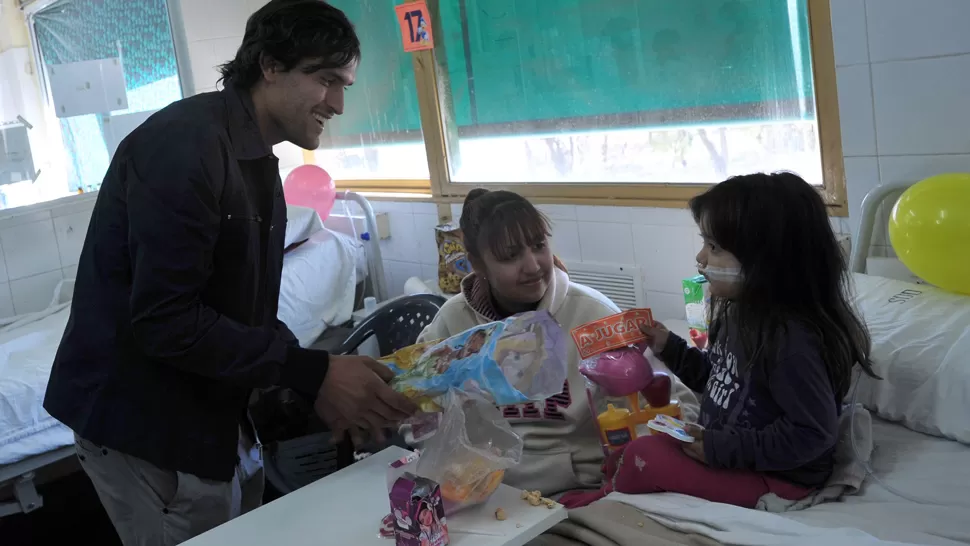 REPARTIENDO ALEGRÍA. Montiglio le entrega juguetes a una nena internada. LA GACETA / FOTO DE DIEGO ARÁOZ