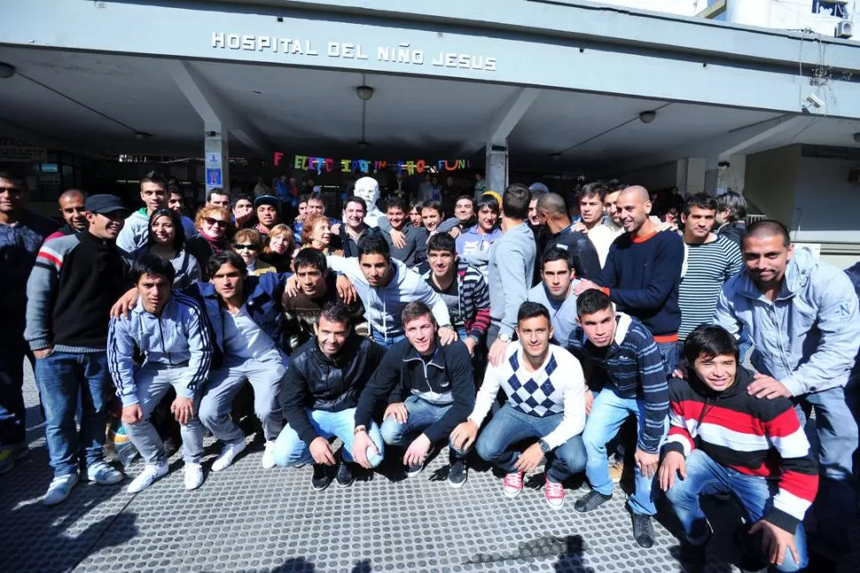 TODOS JUNTOS. Los 22 jugadores que hicieron las visitas pertinentes posan delante de una de las entradas del Hospital de Niños sobre el final del recorrido que realizaron en una combi. 