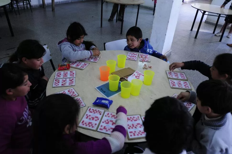 CON BUENAS COMPAÑÍAS. Aramis no va a la escuela, sólo asiste al comedor que está frente a su casa. Ahí le encanta jugar a la lotería con amigos. LA GACETA / FOTOS DE ANALíA JARAMILLO