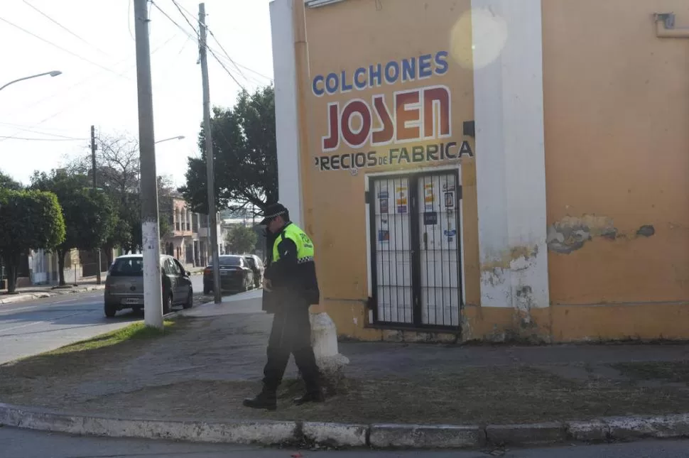 CUSTODIA POLICIAL. Un empleado de la fuerza vigila la esquina de la colchonería, tras el asalto del viernes. 