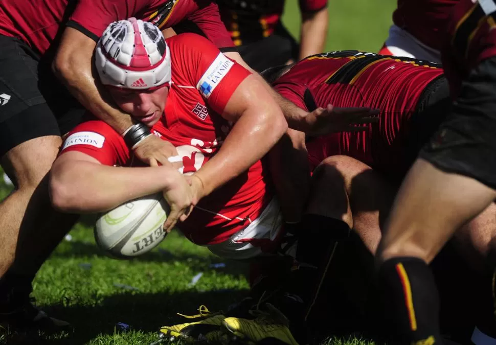 ACOSTÁNDOSE EN EL INGOAL. La multitud de tackles purpurados no logró frenar a Rómulo Acosta, que ya se desploma sobre el césped y marca el tercer try rojo. LA GACETA / FOTO JORGE OLMOS SGROSSO