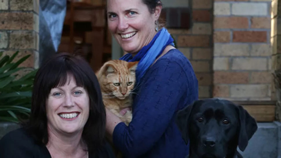 TODOS FELICES. Kim Edwards con su gato Rory y Michelle Whitmore y su perro Maci. FOTO TOMADA DE NZHERALD.CO.NZ