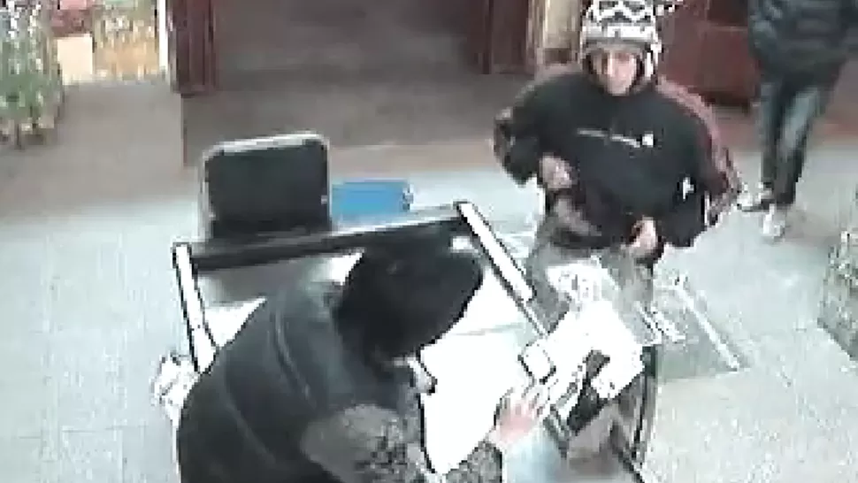 EL COMIENZO. Los hombres entraron al salón y le muestran un arma al cajero, que luego les entregará la recaudación. CAPTURA DE VIDEO