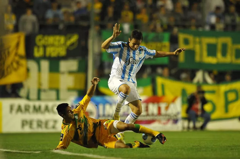 POR ACÁ, NO. Barrado intenta superar la marca de un rival, pero lo anticipan con una toma acrobática y pierde el balón. 