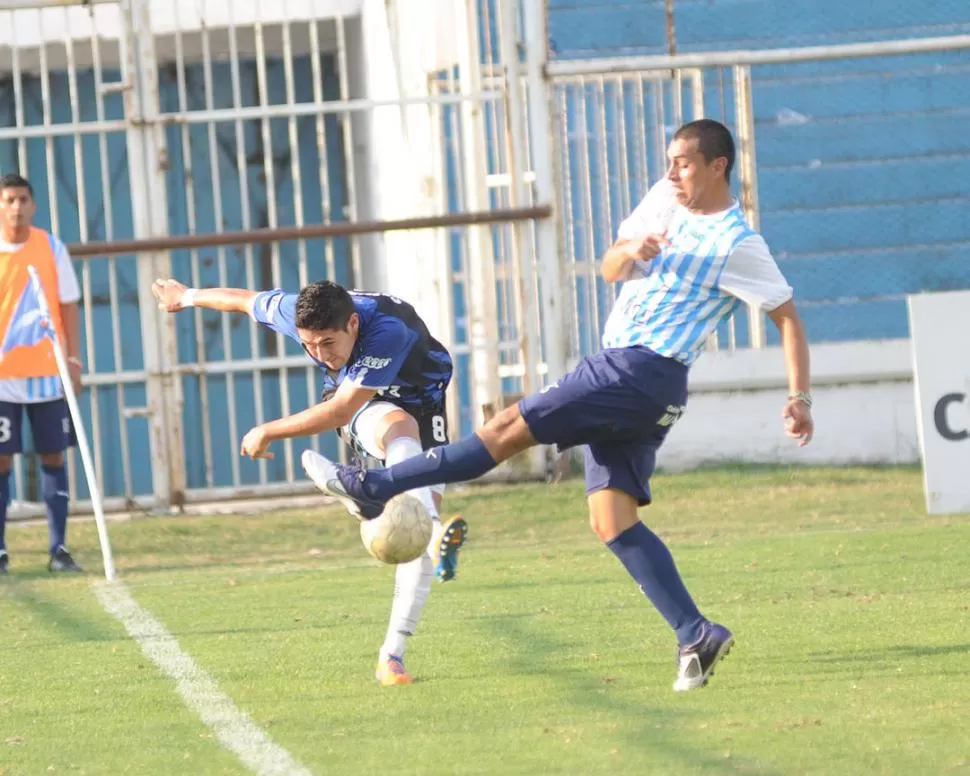 ESFUERZO. Valdez, de Atlético, logra despejar ante la marca de Morales. 