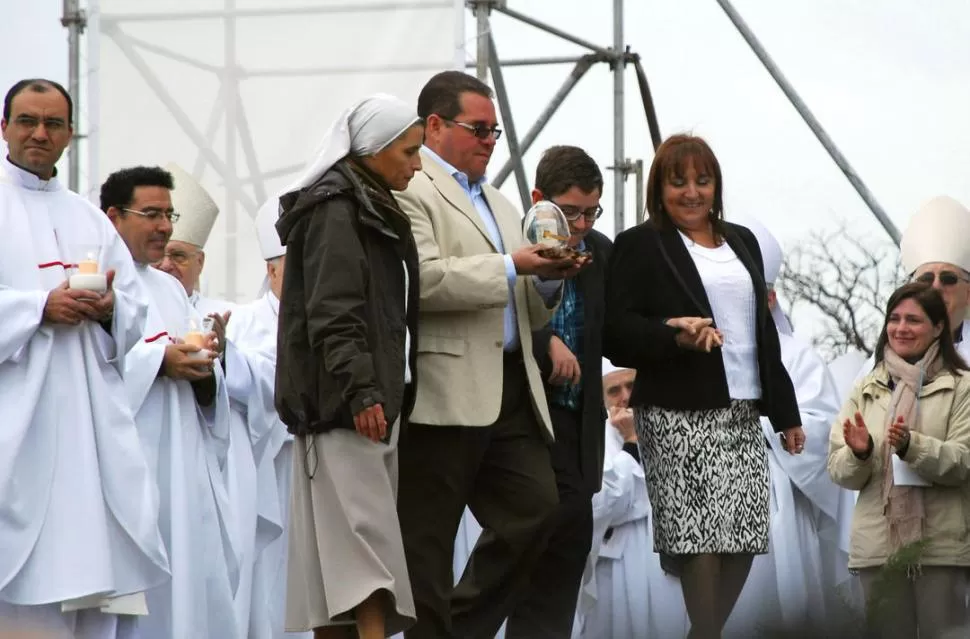 EL MOMENTO MÁS CONMOVEDOR. Ante la presencia de miles de fieles, Nicolás Flores y sus padres subieron al altar con la reliquia del cura gaucho.  