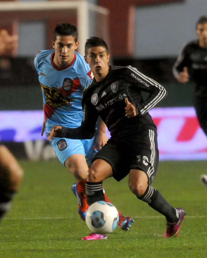 ENGANCHÓ AL PRINCIPIO. Lanzini, que en la foto recibe la pelota ante la mirada de Marcone, jugó de mayor a menor.  DYN