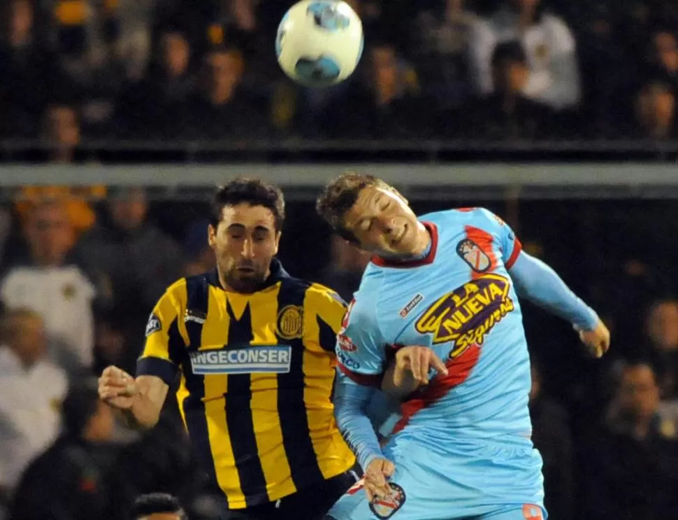 OJOS CERRADOS. Donatti y Furch disputan una pelota aérea durante el partido.  