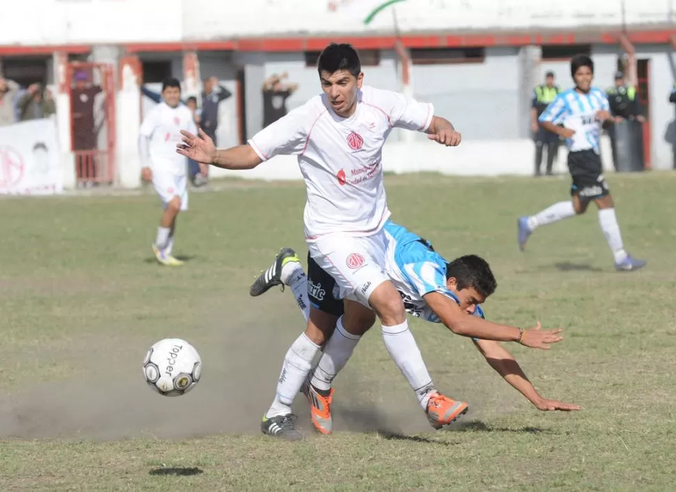 CON DIENTES APRETADOS. Diego Otarola intenta llevarse la pelota ante la dura marca de Andrés Montiel, que termina en el suelo luego de un duro cruce. 