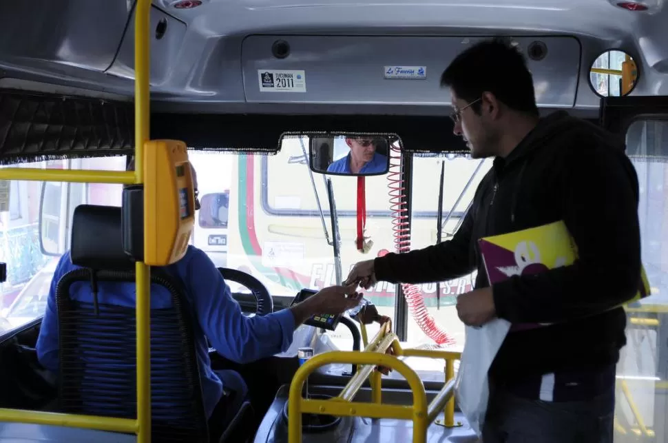 TODAVÍA PREFIEREN EL COSPEL. Un pasajero le paga al colectivero el viaje con un cospel a pesar de que, en primer plano, aparece la máquina registradora de la tarjeta. LA GACETA / FOTO DE ANALIA JARAMILLO 