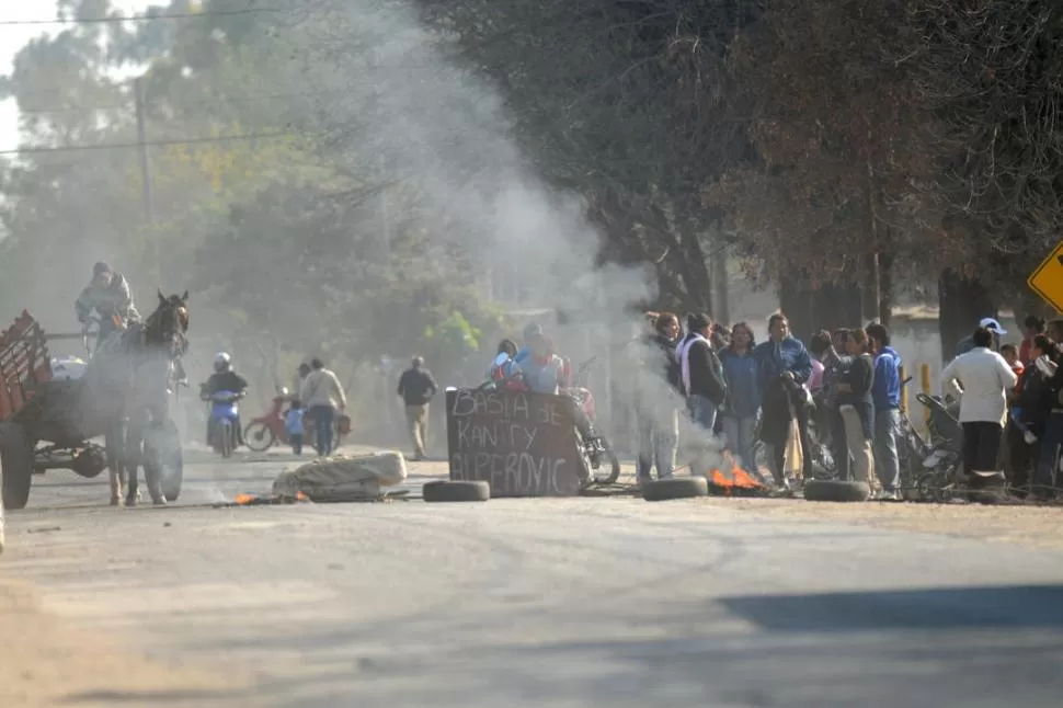 RECLAMO VECINAL. Los desalojados del predio de la ex fábrica cortaron ayer el tránsito sobre Camino del Perú, a la altura de la Curva de los Vega.  LA GACETA / FOTOS DE INéS QUINTEROS ORIO / JORGE OLMOS SGROSSO