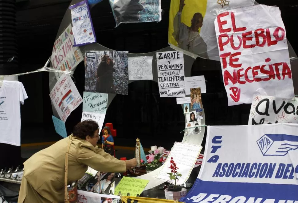 SIN BANDERÍAS. Manos anónimas dejan en la pared del sanatorio mensajes e imágenes que resumen el deseo de pronta recuperación de la Presidenta. DYN