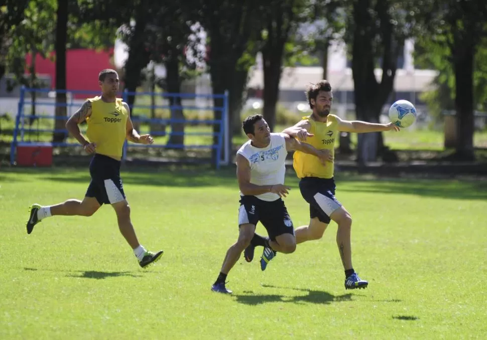 LUCHA. Romat, que jugará de lateral derecho, disputa la pelota con Longo, en el entrenamiento de ayer en Ojo de Agua. 