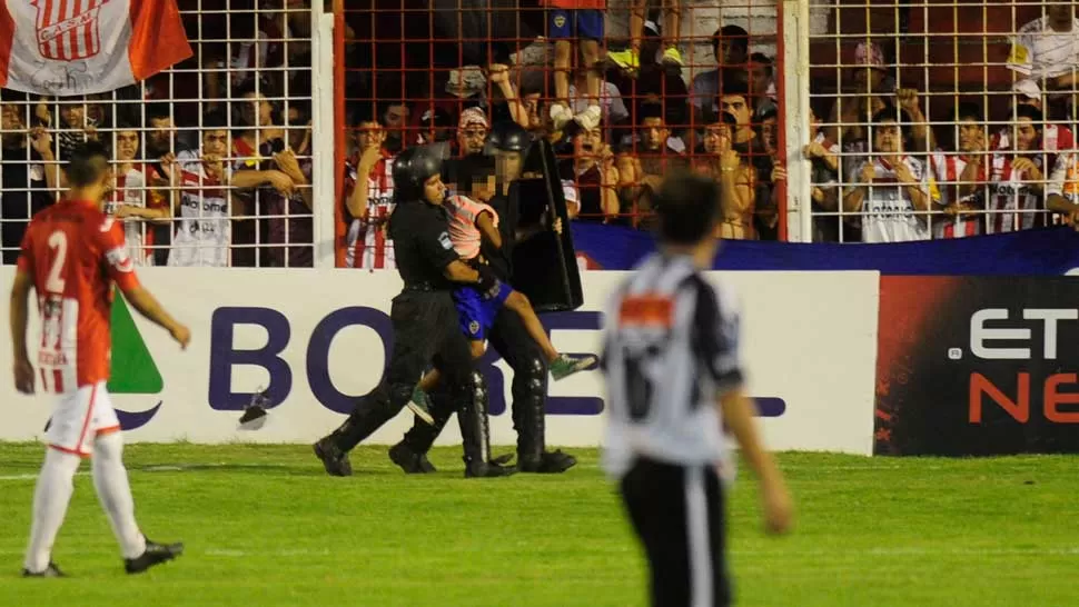 LA IMAGEN QUE ENFURECIÓ A TODOS. A la fuerza, dos policías retiran a un nene del  campo. LA GACETA / JORGE OLMOS SGROSSO