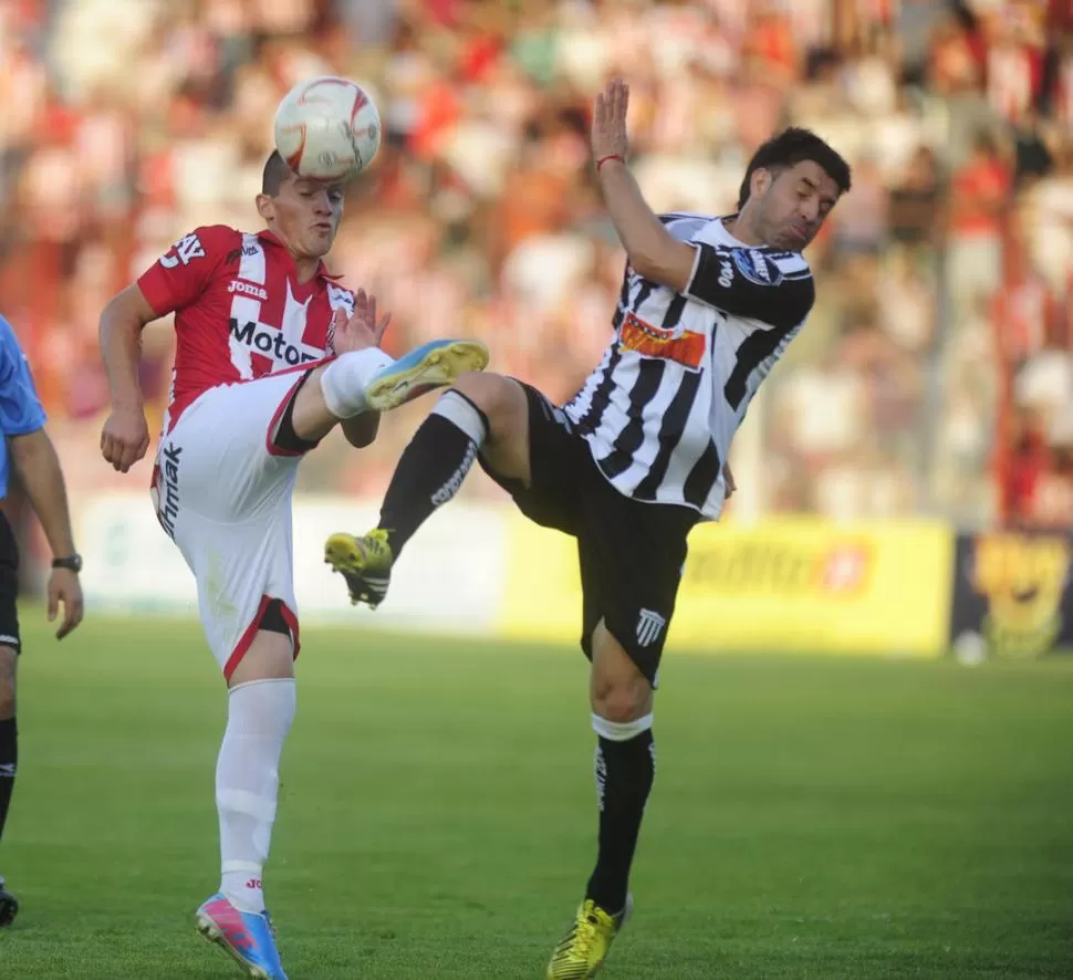 CON TODO. Maximiliano Rodríguez, que cumplió con una gran labor, lucha por la posesión de la pelota ante Franco Amaya. 