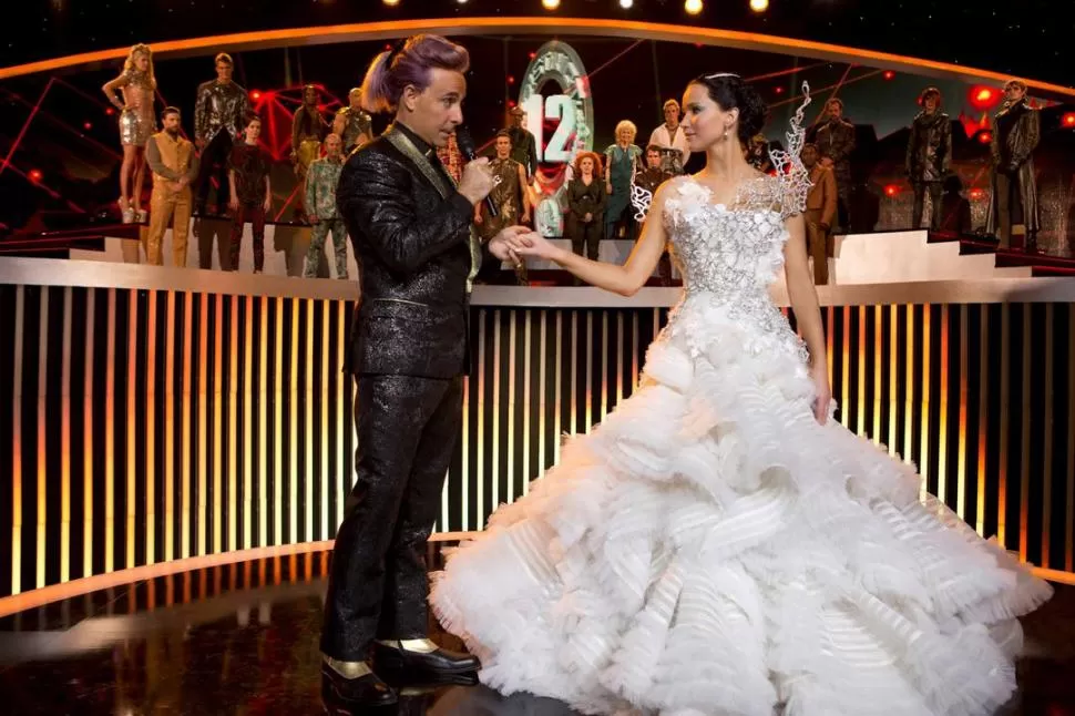 COMO UNA REINA. Así presenta Caesar Flickerman (Stanley Tucci) a la aguerrida Katniss (Jennifer Lawrence). 