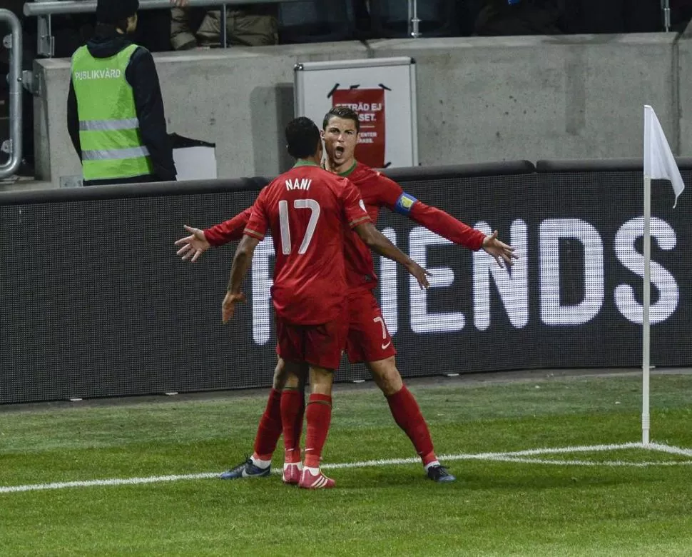 DETERMINANTE. CR7, que le hizo los tres goles a Suecia, festeja con Nani. 