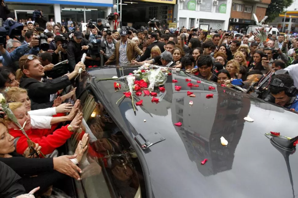 ÚLTIMO ADIÓS. Los seguidores de Fort no pudieron pasar al velorio, pero depositaron flores en el auto fúnebre. 