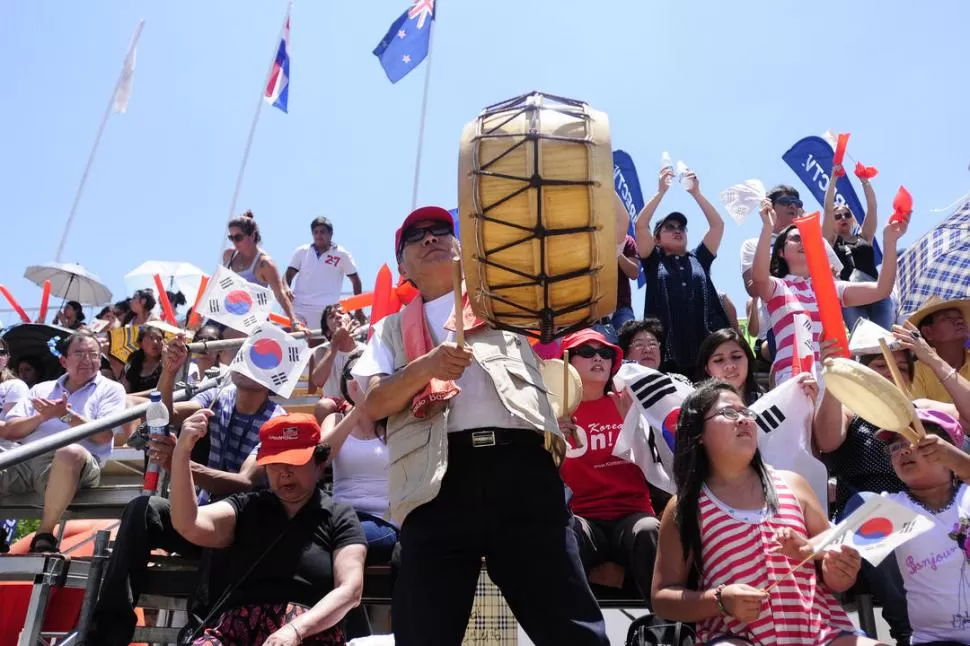 DIRIGE LA BATUTA. Wong encabeza la hinchada de surcoreanos, que alienta a su equipo con banderas y mucha onda. Además, suma voces tucumanas a sus cantos. Claro que aspiran a celebrar un triunfo. 