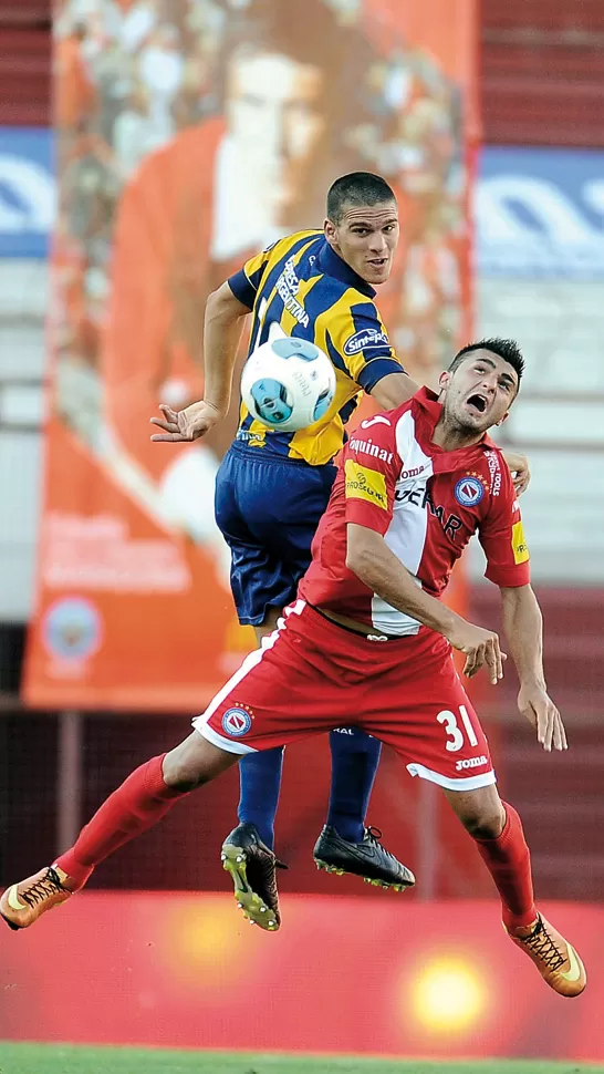 
PELEA EN LAS ALTURAS. Enrique Triverio disputa la pelota con un defensor rival. TELAM