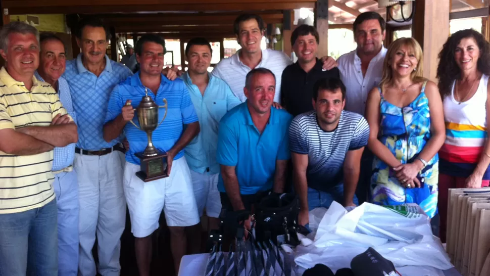 INSTANTÁNEA. Sebastián Gómez Paravan sostiene la Copa Challenger Osde, rodeados de otros médicos y jugadores de golf. PRENSA JOCKEY CLUB 